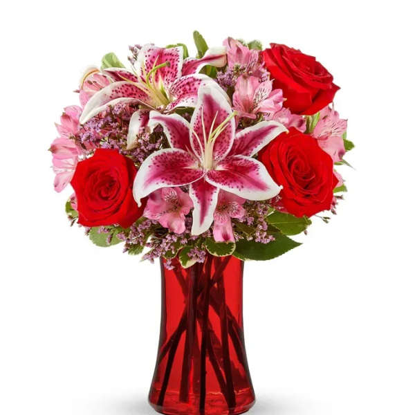 Red roses and pink lilies in a red glass vase