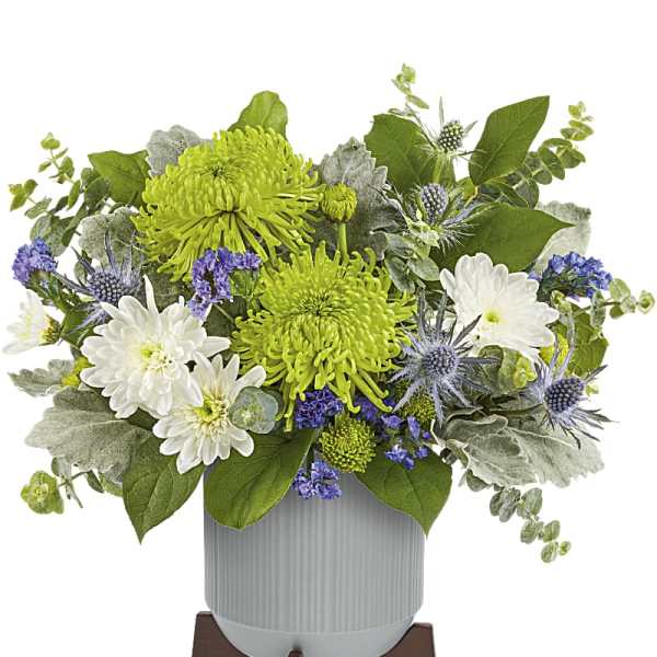 White and green floral arrangement in a gray vase