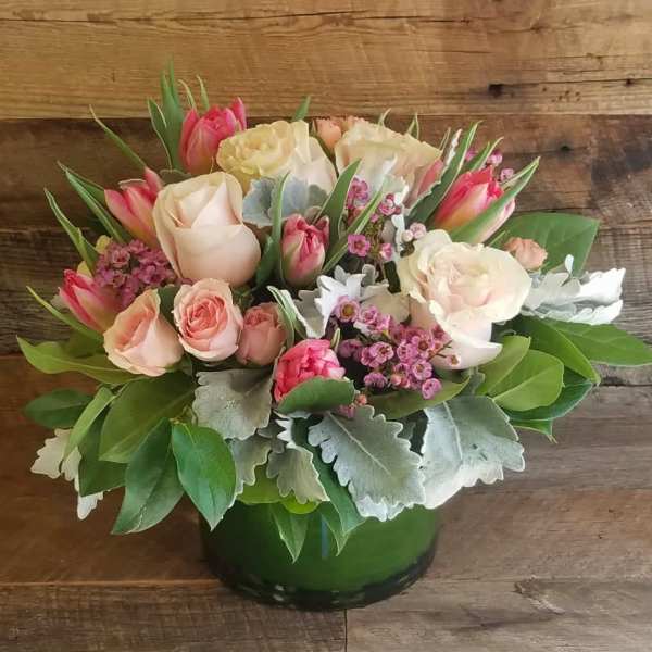 Pink and cream roses with tulips in a green vase