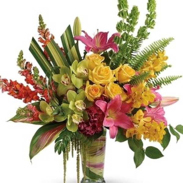 Tropical bouquet in a glass vase with pink lilies and yellow orchids