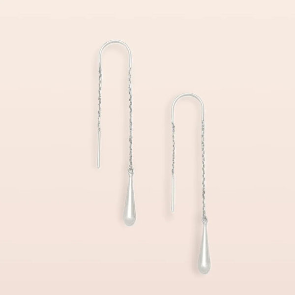 Pair of silver threader earrings with teardrop dangles on a light background