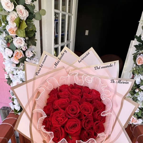 Large bouquet of red roses wrapped in pink paper