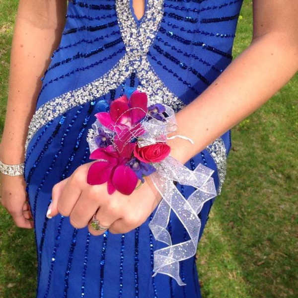 Girl in a blue dress wearing a pink flower wrist corsage