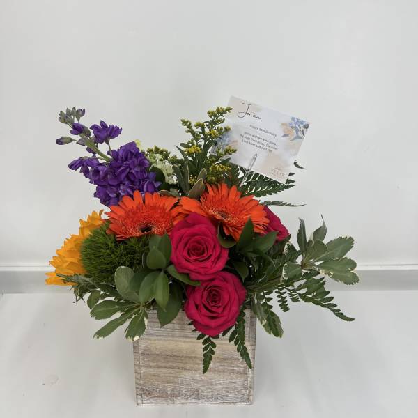 Mixed bouquet in a wooden box with pink roses and orange gerberas