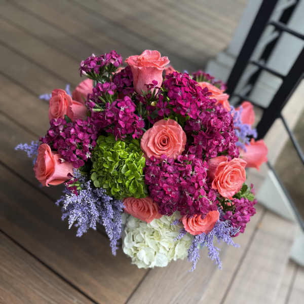Bouquet of pink roses, magenta blooms, and white hydrangea