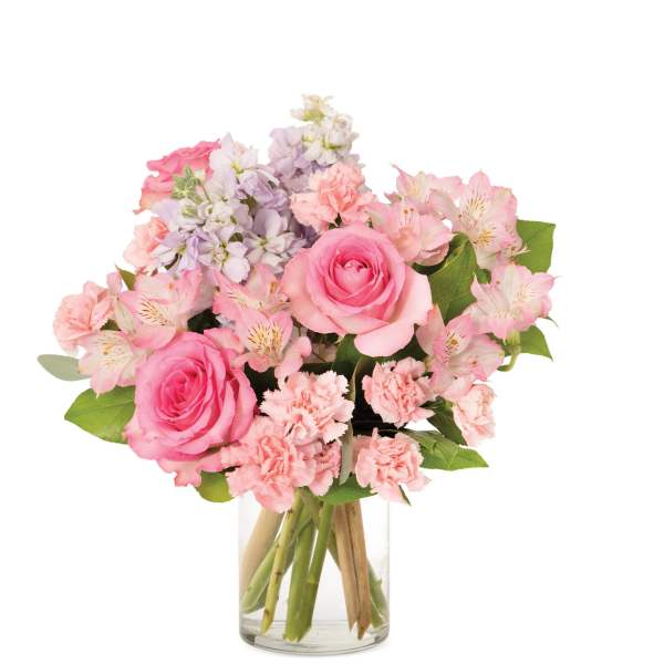 Pink rose, carnation, and alstroemeria bouquet with lavender stock in a clear glass vase