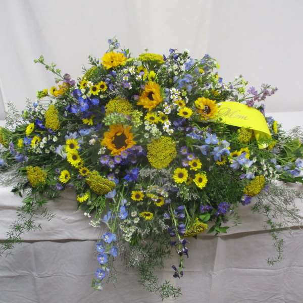 Large mixed floral spray with yellow and blue flowers on a table