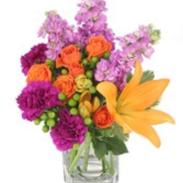 Colorful bouquet of orange and purple flowers in a clear glass vase