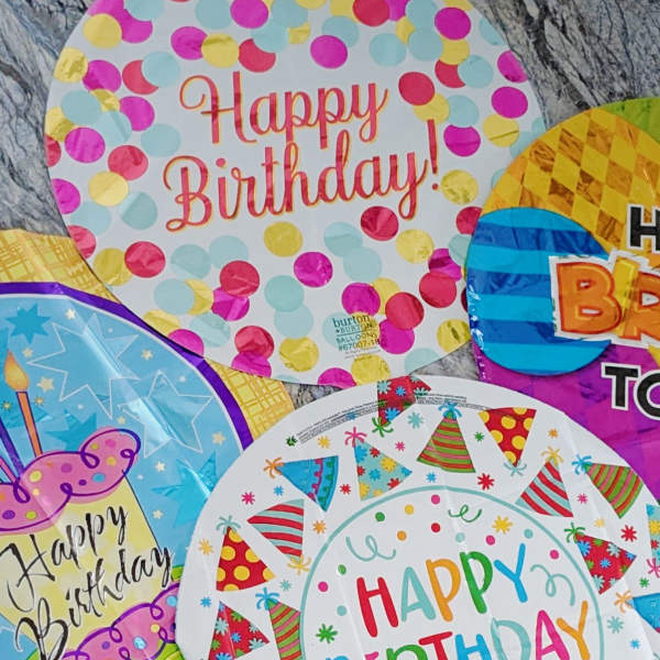 Assorted birthday balloons with colorful confetti and party hat designs