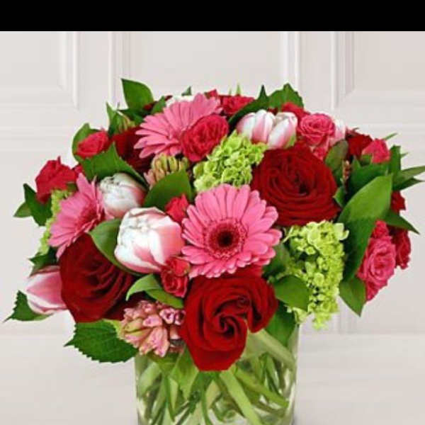 Bouquet of red and pink flowers in a clear glass vase