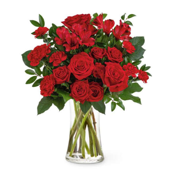 Red roses and carnations in a clear glass vase