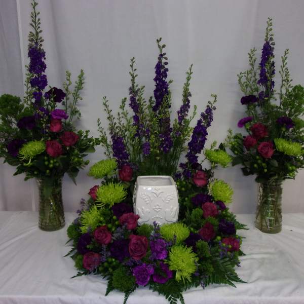 Purple and green floral funeral set with a white urn in the center