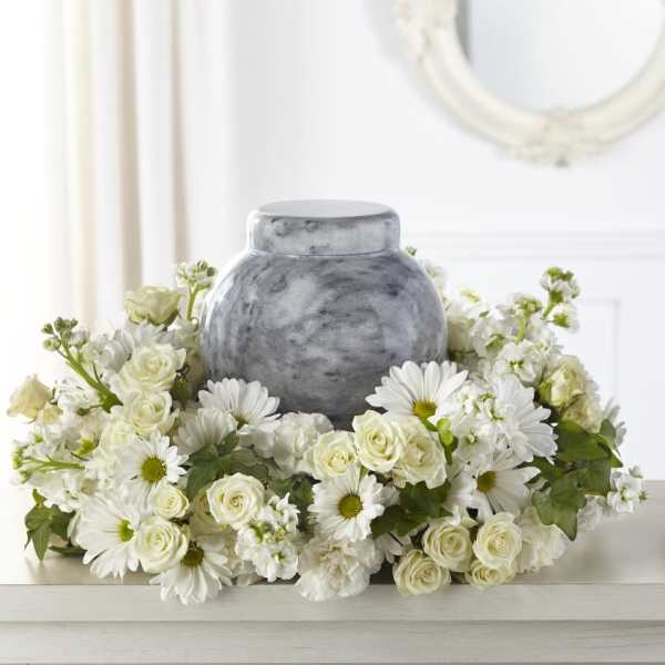 White floral arrangement surrounding a gray urn
