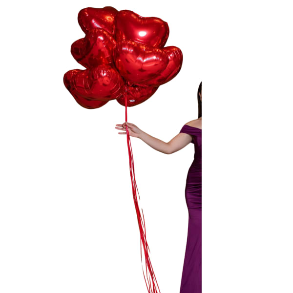 Cluster of red heart-shaped balloons held by a woman in a purple dress