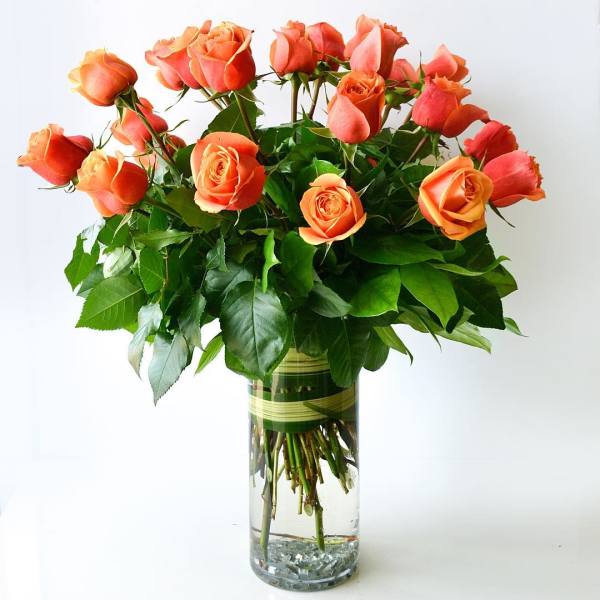 Orange roses arranged in a clear glass vase