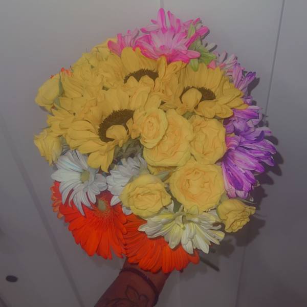 Handheld bouquet of yellow, pink, purple, white, and orange flowers