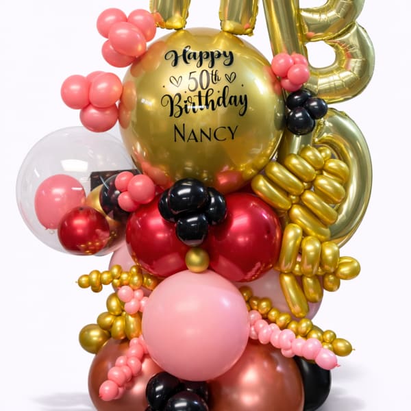 Gold 50th birthday balloon arrangement with pink and black accents