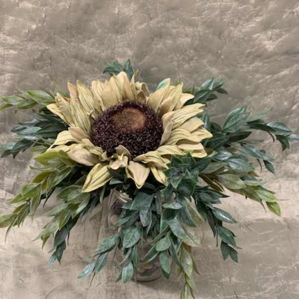 Sunflower arrangement in a vase with cascading greenery