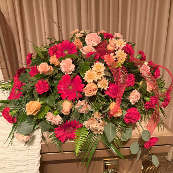 Large casket spray with pink and peach flowers