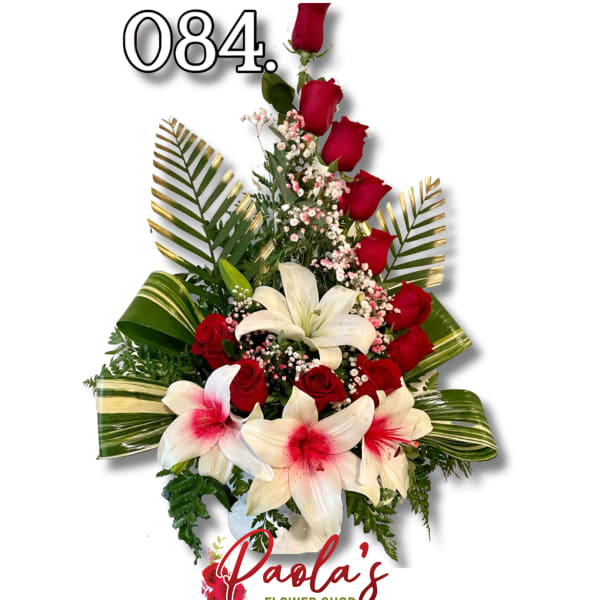 Tall arrangement of red roses and white lilies with pink filler flowers