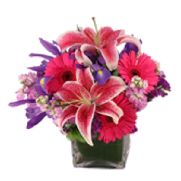 Pink lilies and gerbera daisies in a square glass vase