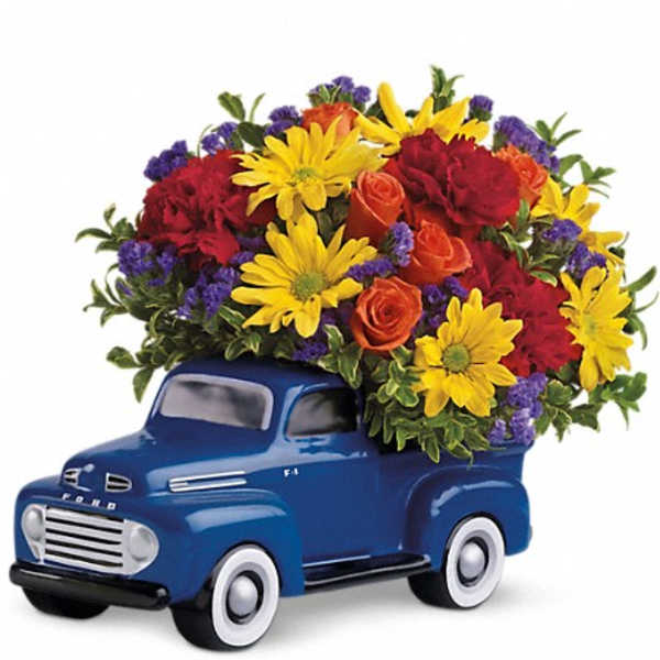 Blue toy truck topped with a colorful flower arrangement