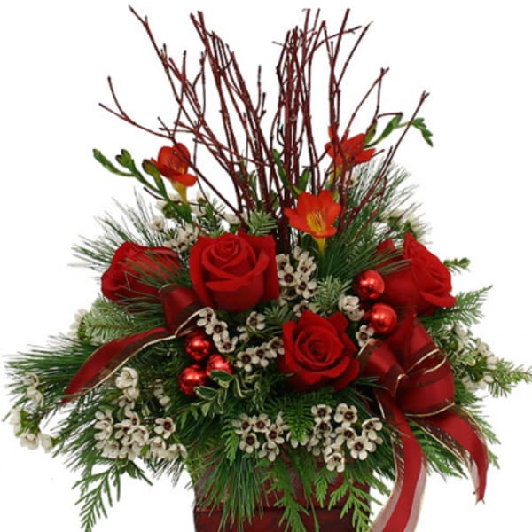 Red roses and orange flowers in a festive holiday arrangement with ribbons