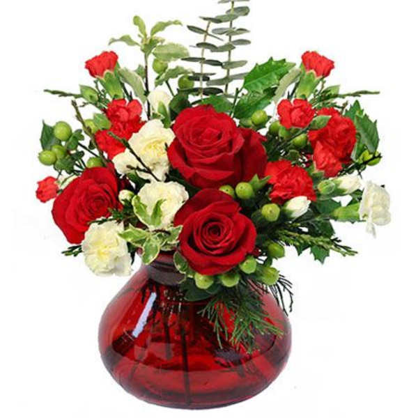 Red and white rose arrangement in a red glass vase