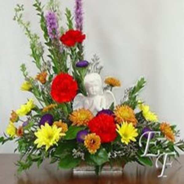 Colorful floral arrangement with a white angel figurine