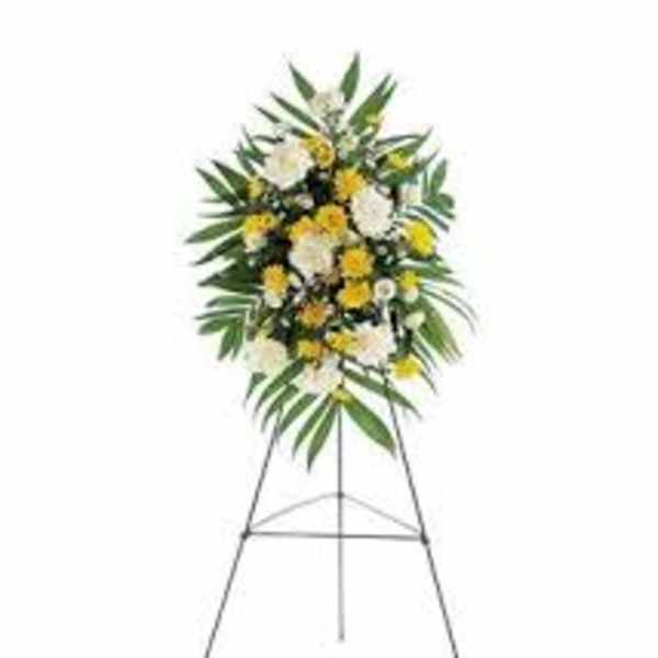 Standing floral spray with white and yellow flowers on an easel