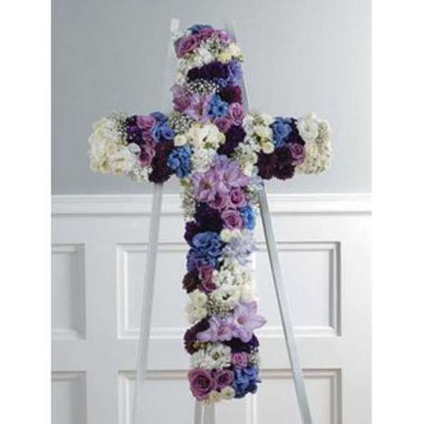 Floral cross-shaped standing arrangement in purple, blue, and white flowers