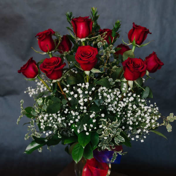 Bouquet of red roses with baby's breath in a glass vase