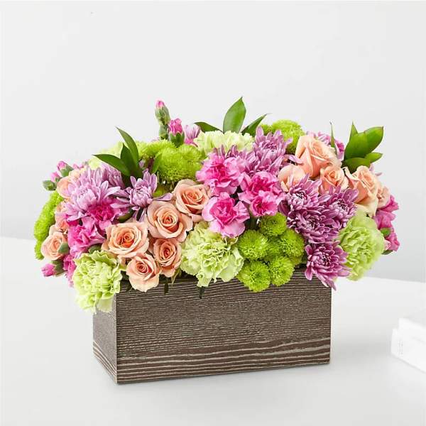 Mixed pink and green floral arrangement in a rectangular wooden box