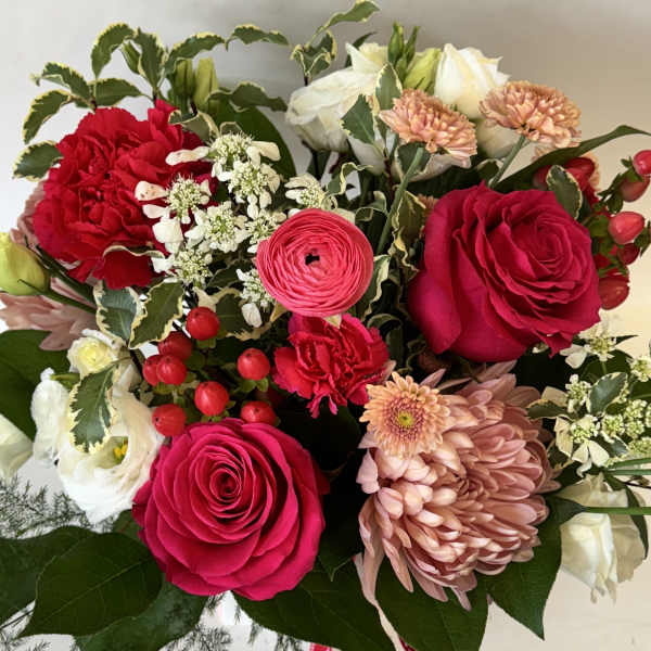 Bouquet of red and white roses with pink chrysanthemums and berries