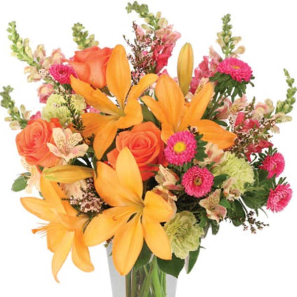 Tall bouquet of orange lilies and roses with pink blooms in a clear glass vase