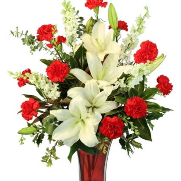 Tall vase arrangement of white lilies and red carnations with white accent flowers