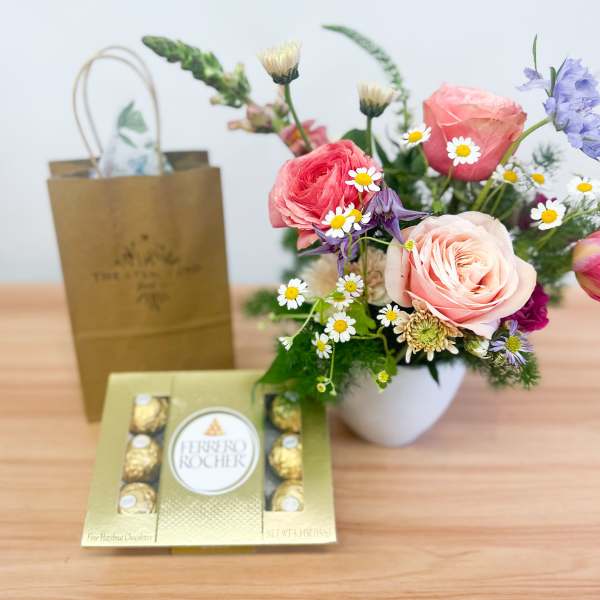 Mixed bouquet in a white vase with a box of Ferrero Rocher chocolates