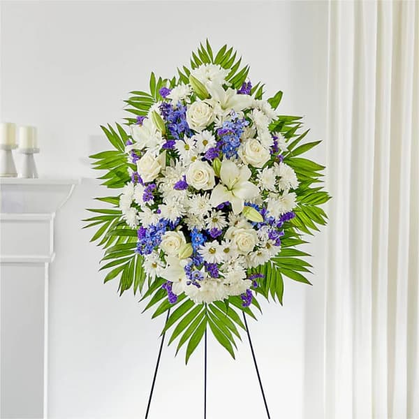 Standing funeral spray of white and purple flowers on an easel