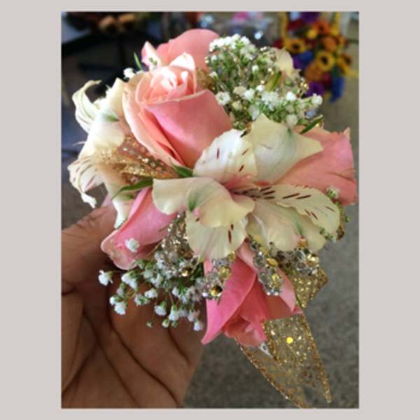 Handheld bouquet of pink roses and white lilies with glittery gold accents