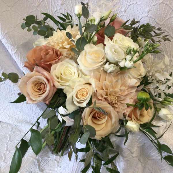 Bouquet of cream and peach roses with greenery