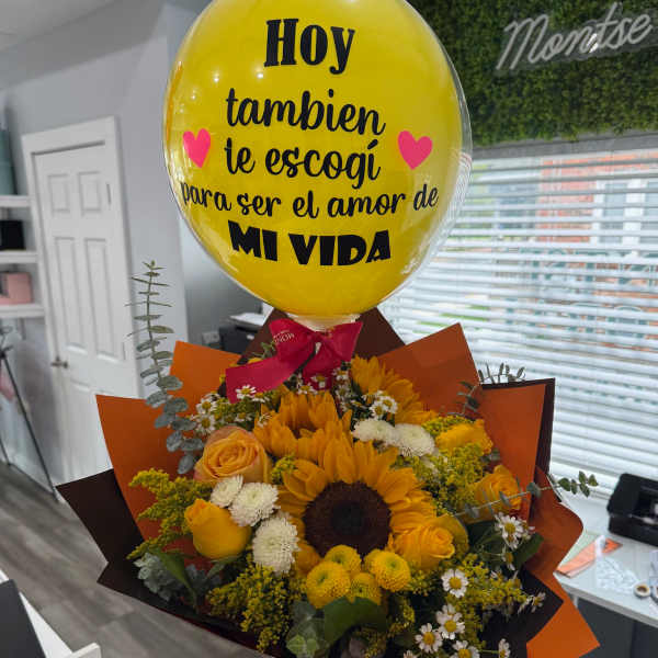 Yellow balloon above a bouquet of sunflowers and roses