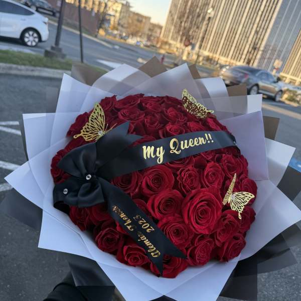 Bouquet of red roses wrapped in black and white paper with a "My Queen" ribbon