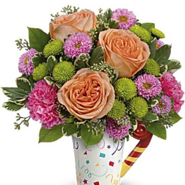 Peach roses and pink flowers in a decorated cup with a candy cane