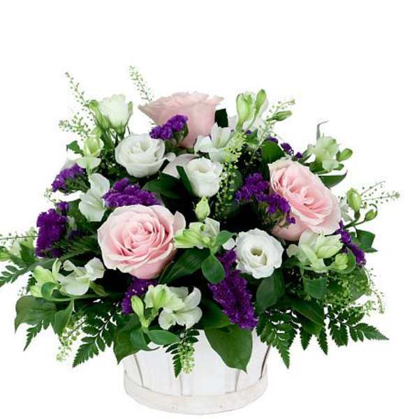 Pink and white roses with purple filler in a white container