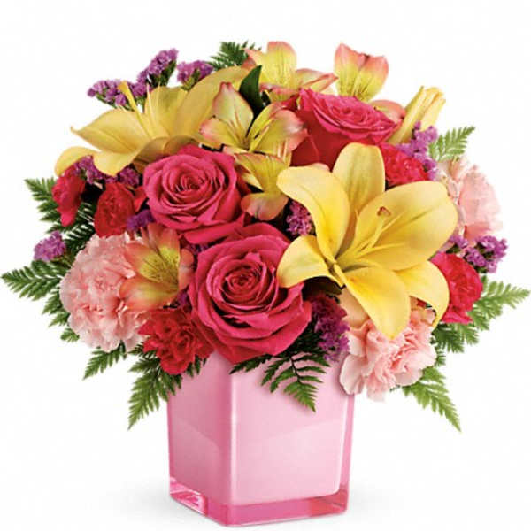 Pink roses and yellow lilies in a pink glass vase