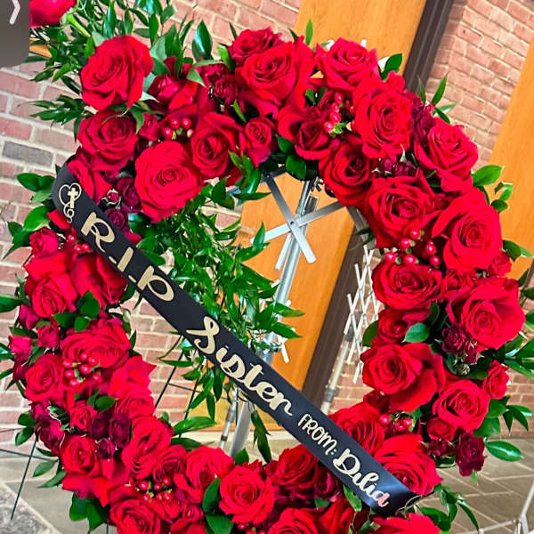 Large red rose funeral wreath with a memorial ribbon