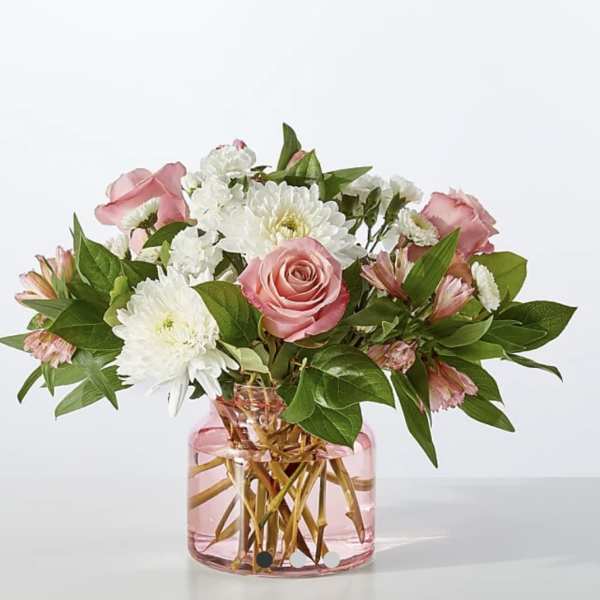 Pink roses and white daisies in a pink glass vase