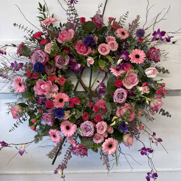 Large wreath of pink and purple flowers with trailing branches