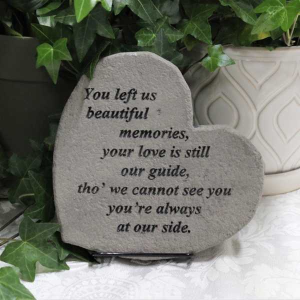 Heart-shaped memorial stone with engraved sympathy message beside potted ivy