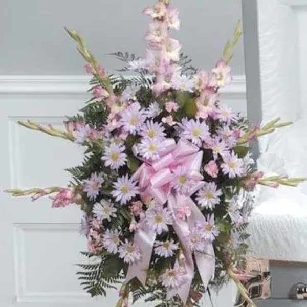Standing floral spray with pink and lavender flowers on a white easel
